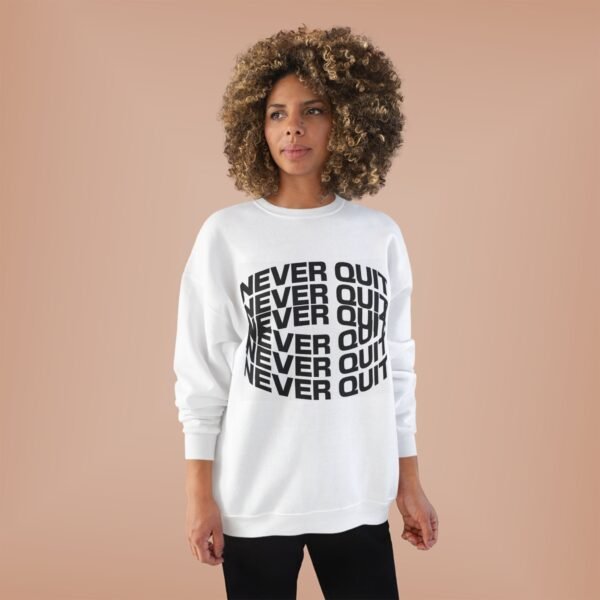 A women wearing a white sweater with the words never quit on the front